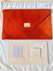 Pochette a busta Jimmy Choo in camoscio aragosta con placca metallica logata