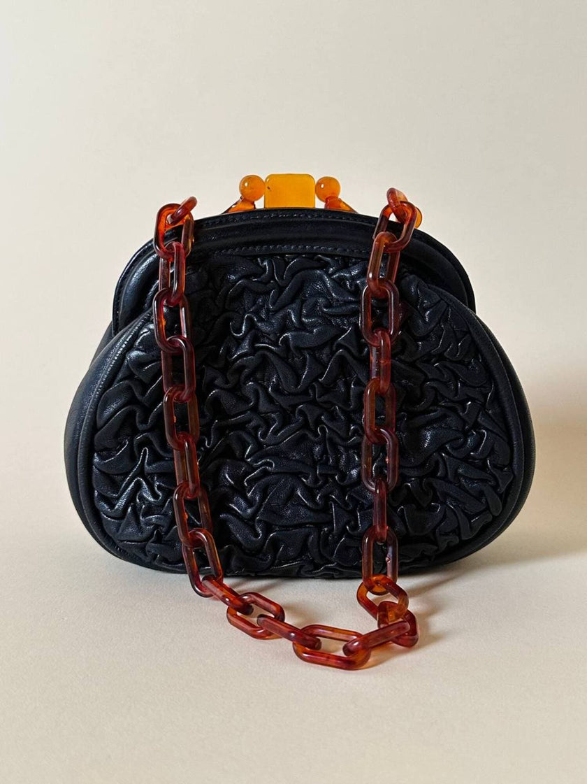 Borsa vintage in pelle nera goffrata con chiusura a scatto e catena in resina ambrata
