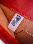 Pochette a busta Jimmy Choo in camoscio aragosta con placca metallica logata