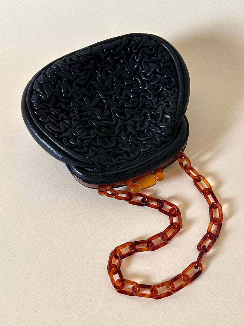 Borsa vintage in pelle nera goffrata con chiusura a scatto e catena in resina ambrata