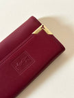 Portachiavi trifold Yves Saint Laurent in pelle rosso granata con dettagli dorati e logo YSL a caldo
