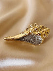 Spilla dorata con strass a forma di conchiglia Bolinus
