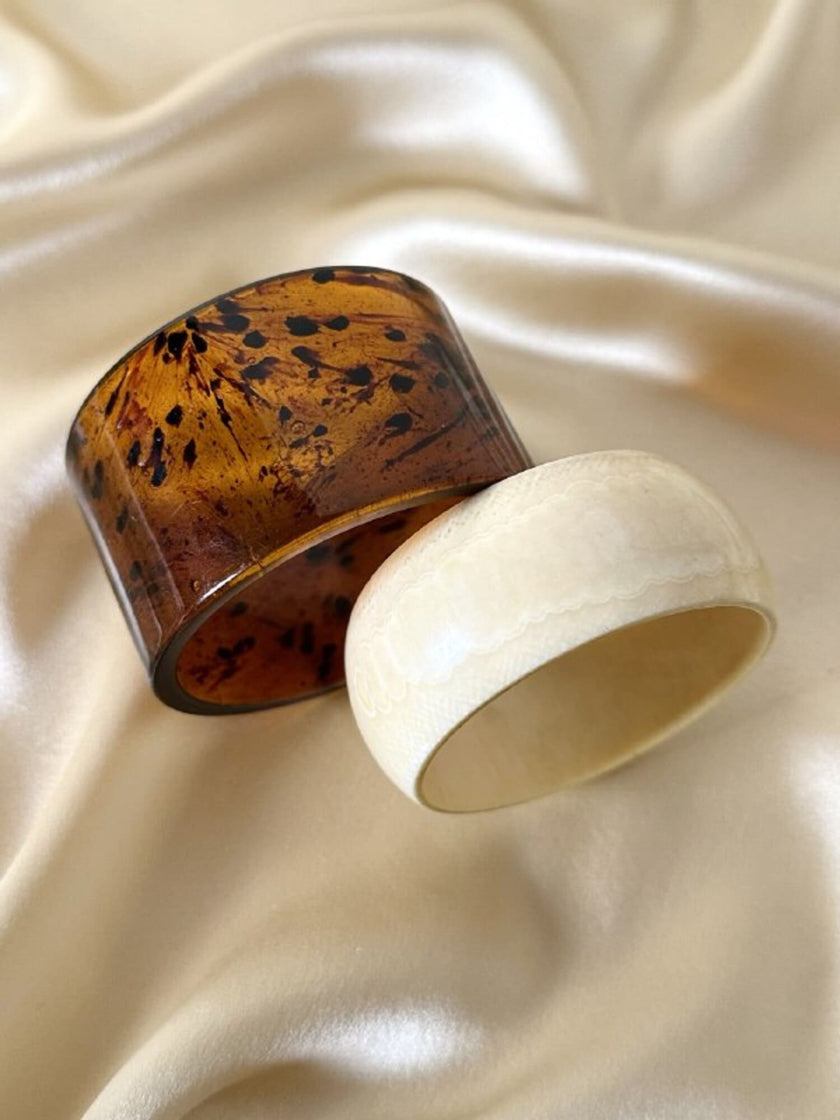 Coppia di bracciali rigidi in acrilico tartarugato e resina effetto avorio