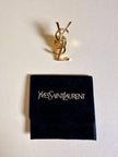 Spilla logo YSL dorata con dust nera “Yves Saint Laurent”