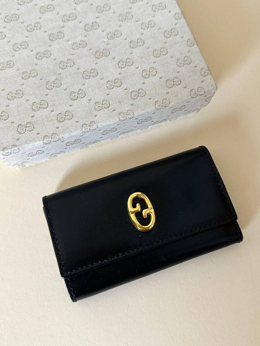 Portachiavi trifold Gucci in pelle nera con logo in metallo oro e scatola originale