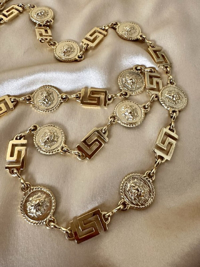 Cintura/collana dorata composta da greche e teste di leone