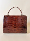 Borsa a trapezio in pelle di coccodrillo color cognac con tracolla e hardware oro Idra
