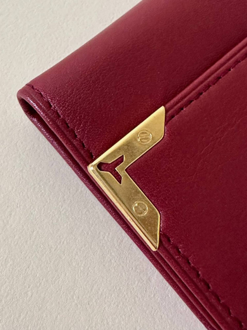 Portachiavi trifold Yves Saint Laurent in pelle rosso granata con dettagli dorati e logo YSL a caldo