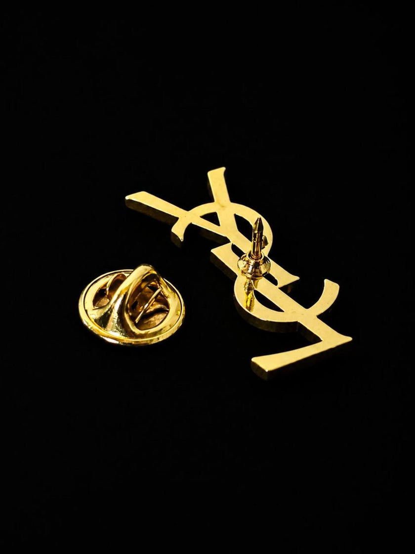 Vintage Yves Saint Laurent logo brooch in gold-tone metal