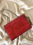 Borsa rossa in coccodrillo con borchie argento e tracolla metallica “Nicolette”