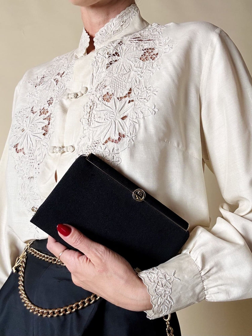 Mini pochette in tessuto nero con chiusura logata color oro “Gucci”