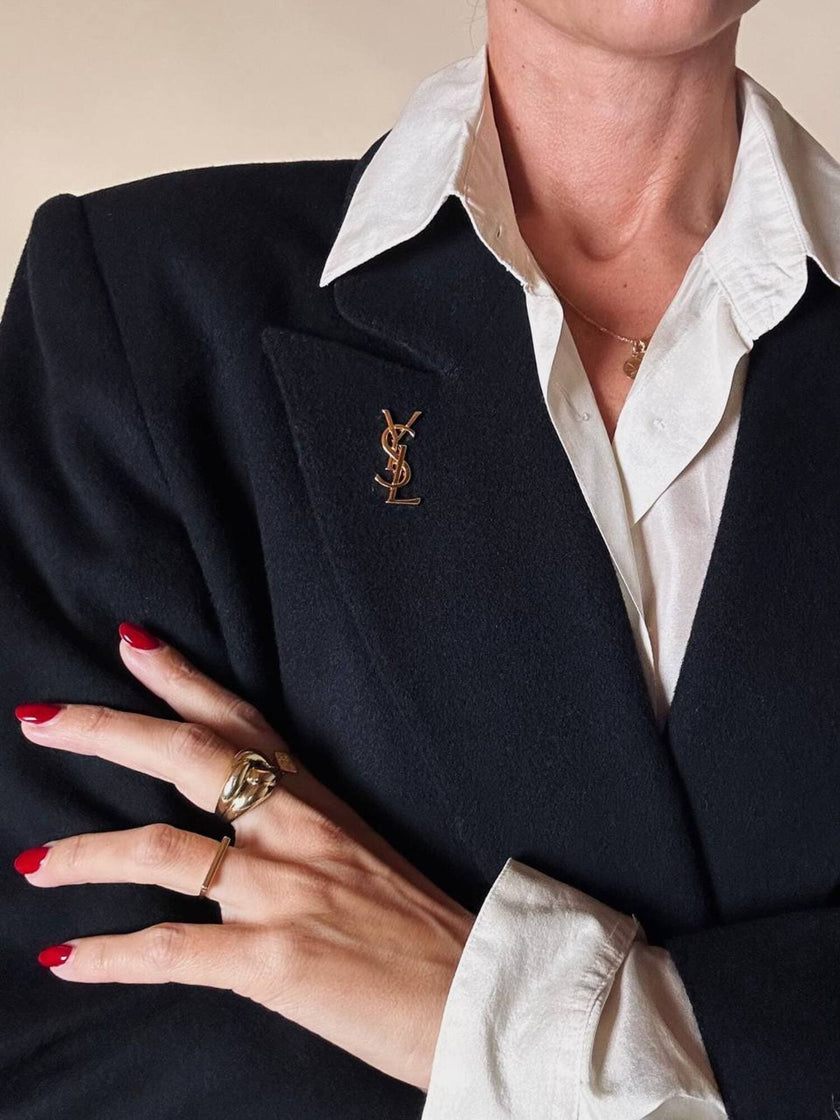 Spilla logo YSL dorata con dust nera “Yves Saint Laurent”