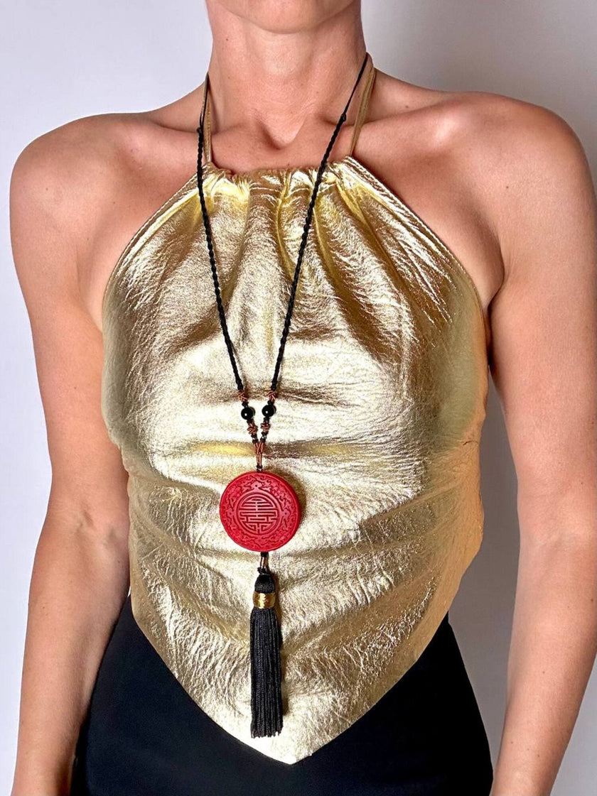 Top vintage con schiena nuda in pelle laminata oro