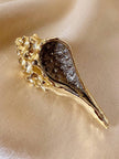 Spilla dorata con strass a forma di conchiglia Bolinus