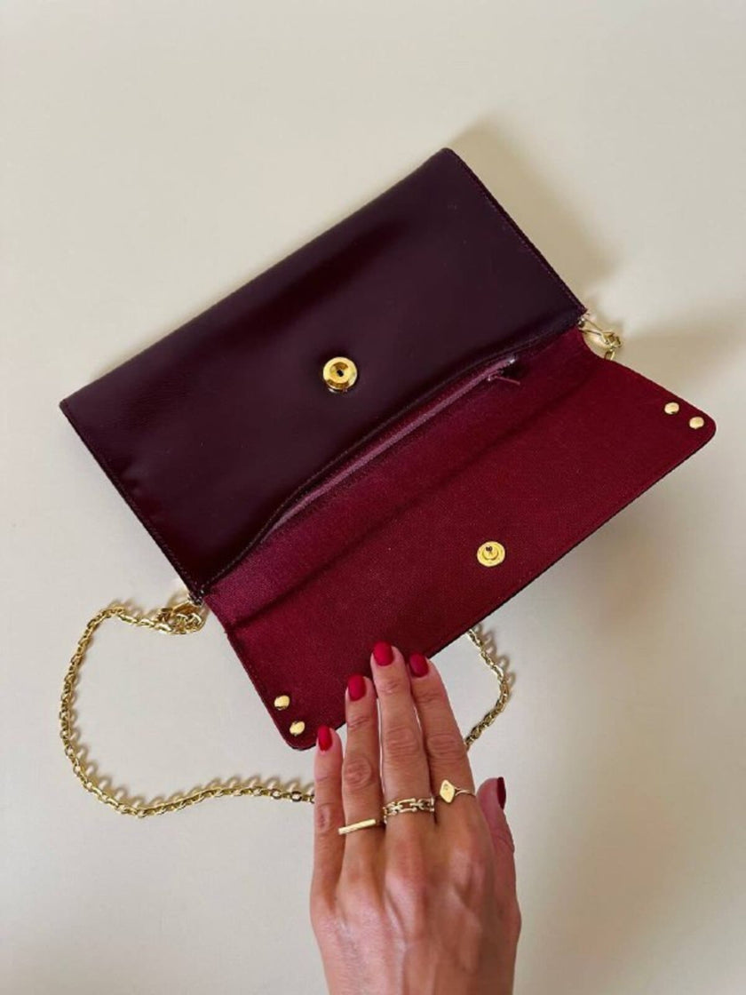 Pochette in pelle spazzolata bordeaux con tracolla in catena