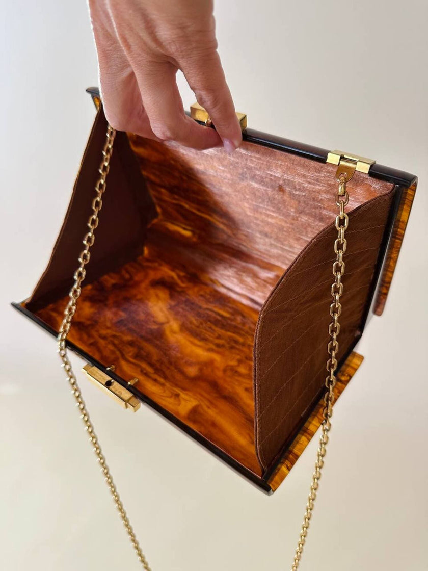 Bolso rígido Marie Antoinette de lucita con efecto carey y correa de cadena dorada