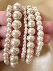 Set di cinque bracciali con perle sintetiche bianche