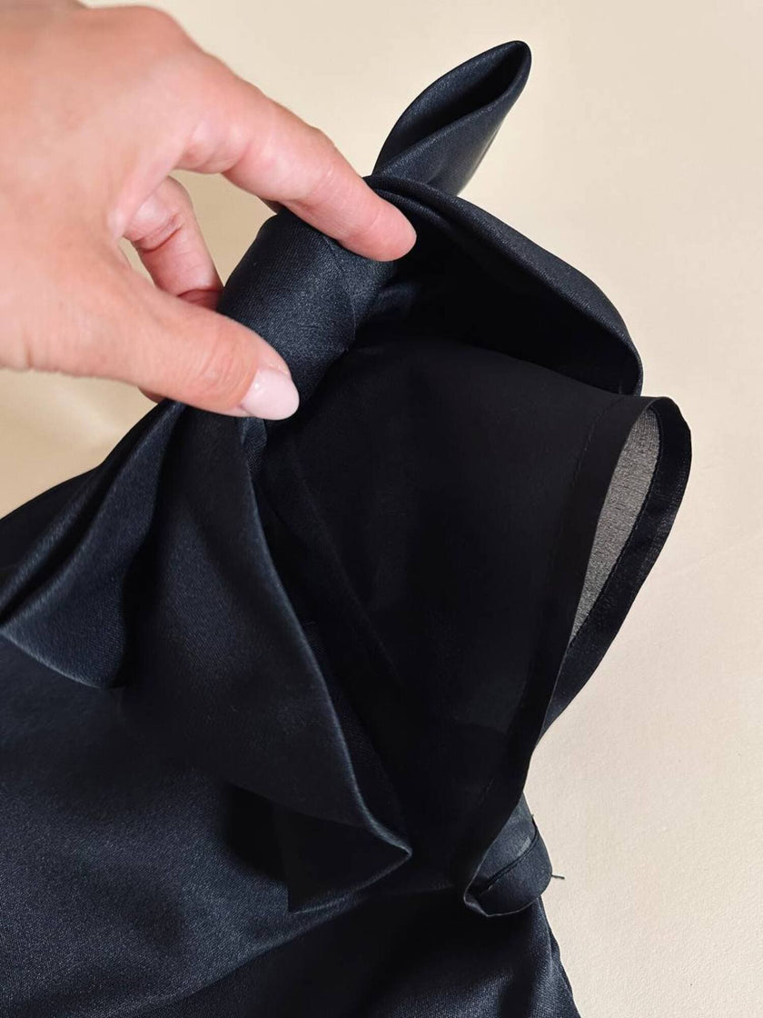 Top in seta nera con spalle scoperte e maxi fiocchi “Istante