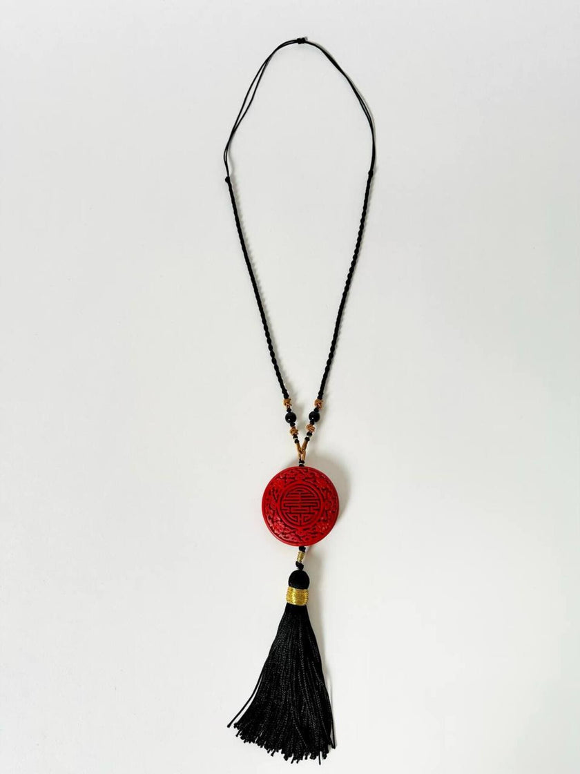 Collana vintage in stile orientale con ciondolo rotondo in cinabro rosso e nappa couture