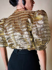 Blusa in lamè goffrato oro con maniche a palloncino e bottoni gioiello