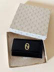 Portachiavi trifold Gucci in pelle nera con logo in metallo oro e scatola originale