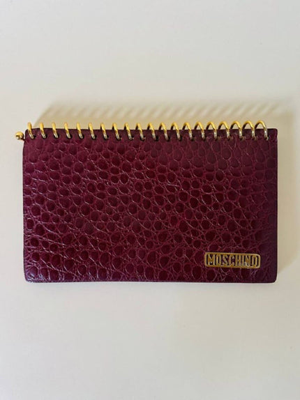 Pochette a quaderno in pelle bordeaux stampa coccodrillo “Moschino”