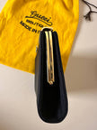 Mini pochette in tessuto nero con chiusura logata color oro “Gucci”