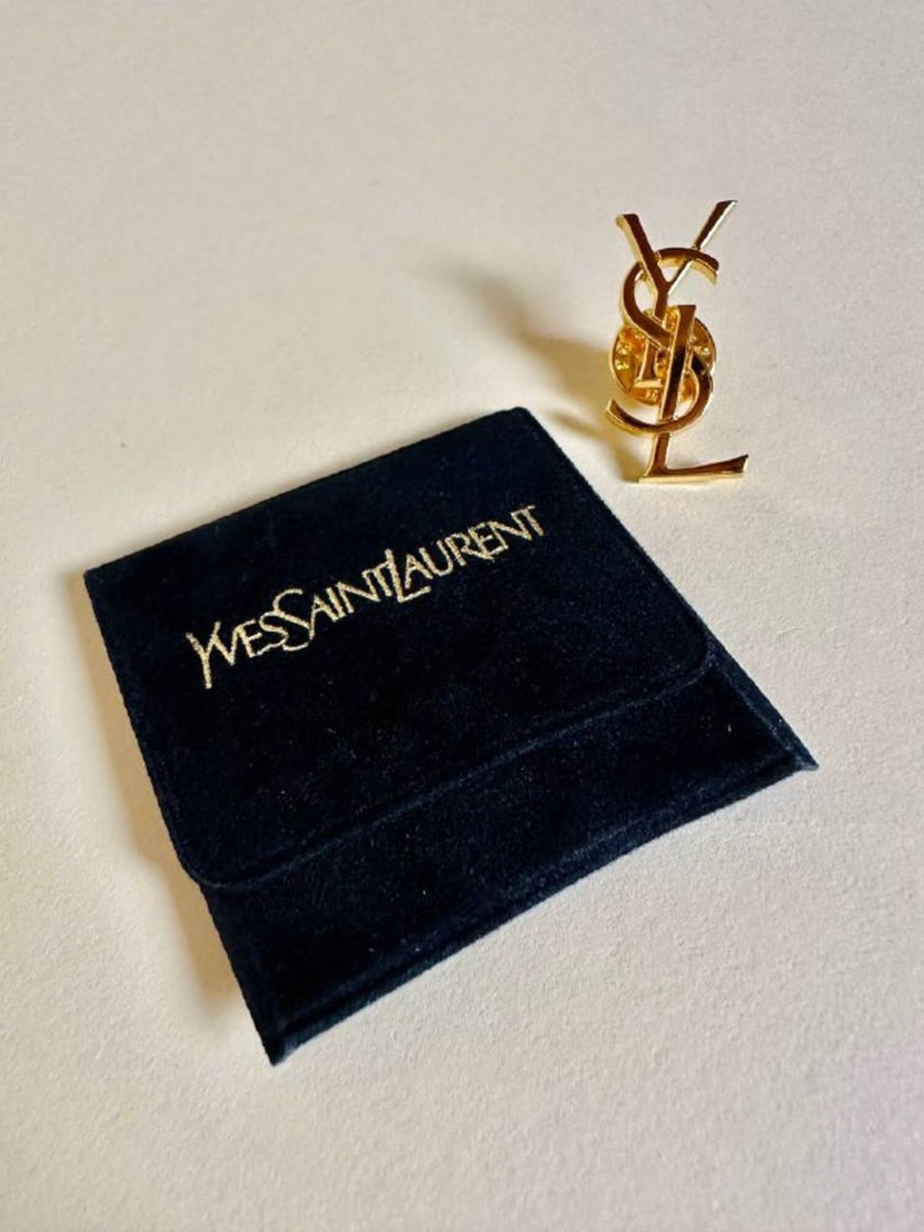 Spilla logo YSL dorata con dust nera “Yves Saint Laurent”