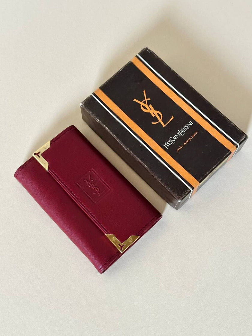 Portachiavi trifold Yves Saint Laurent in pelle rosso granata con dettagli dorati e logo YSL a caldo