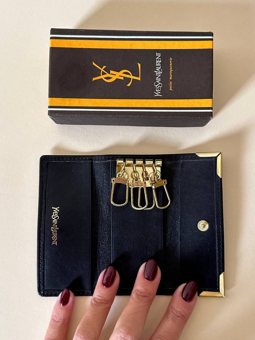 Porte-clés trifold Yves Saint Laurent en cuir noir avec détails dorés et logo YSL embossé
