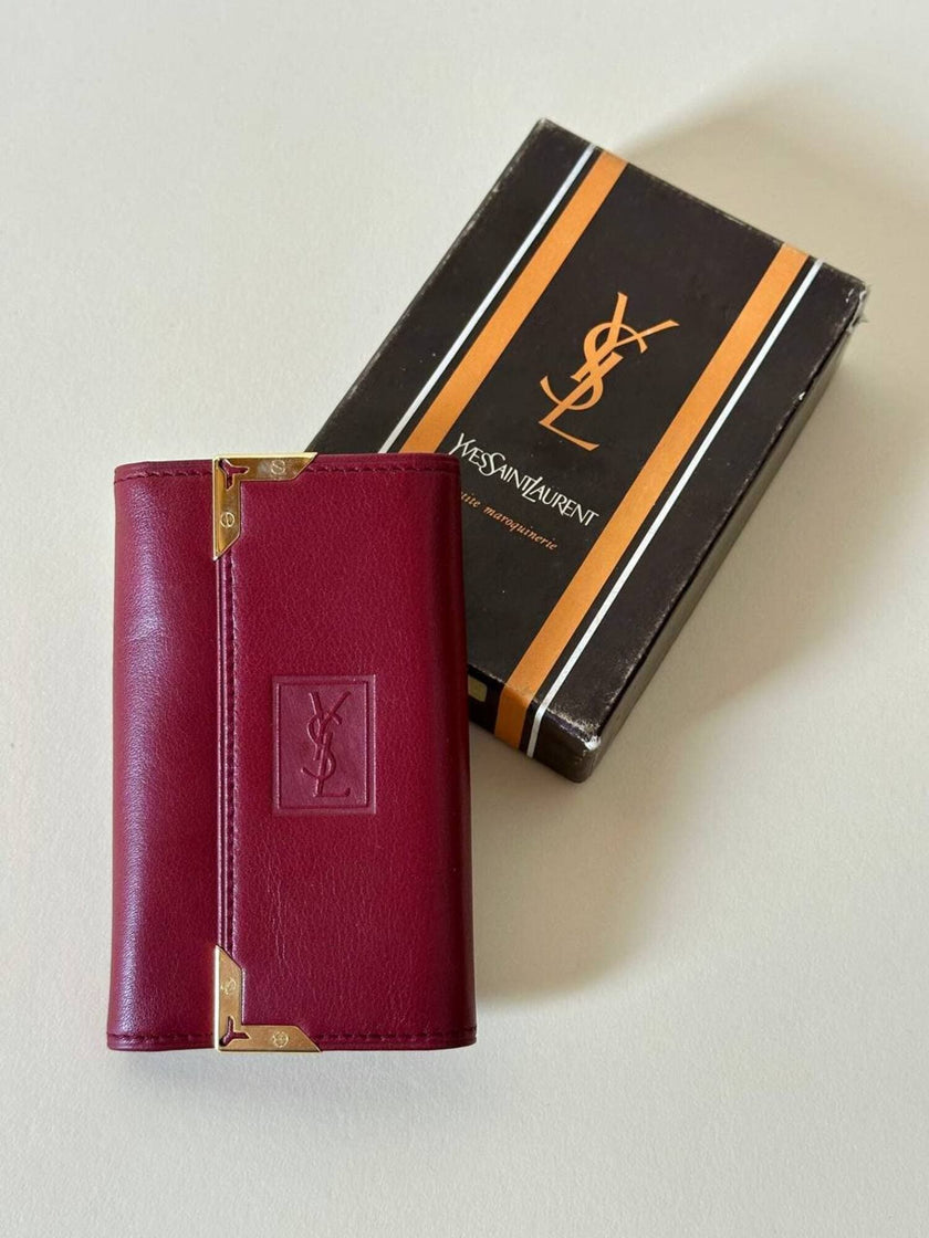 Portachiavi trifold Yves Saint Laurent in pelle rosso granata con dettagli dorati e logo YSL a caldo