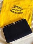 Mini pochette in tessuto nero con chiusura logata color oro “Gucci”