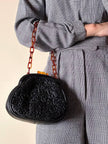 Borsa vintage in pelle nera goffrata con chiusura a scatto e catena in resina ambrata