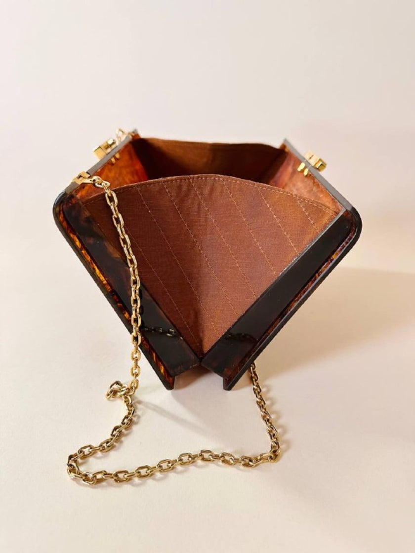 Bolso rígido Marie Antoinette de lucita con efecto carey y correa de cadena dorada