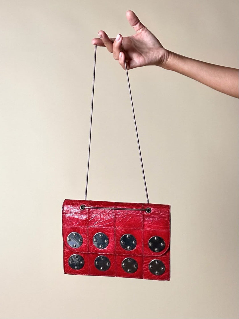 Borsa rossa in coccodrillo con borchie argento e tracolla metallica “Nicolette”