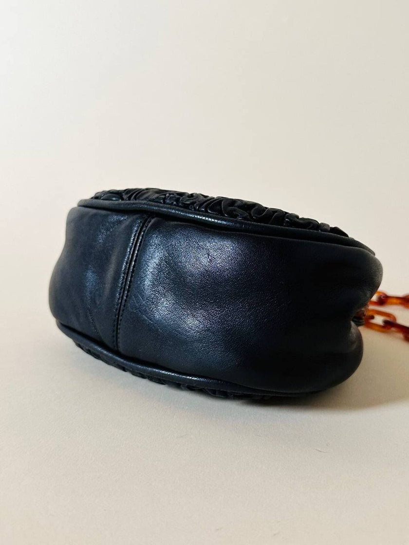 Borsa vintage in pelle nera goffrata con chiusura a scatto e catena in resina ambrata