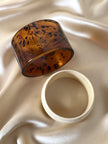 Coppia di bracciali rigidi in acrilico tartarugato e resina effetto avorio