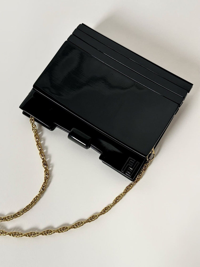 Borsa vintage Fendi in lucite nera con logo inciso e tracolla a catena dorata