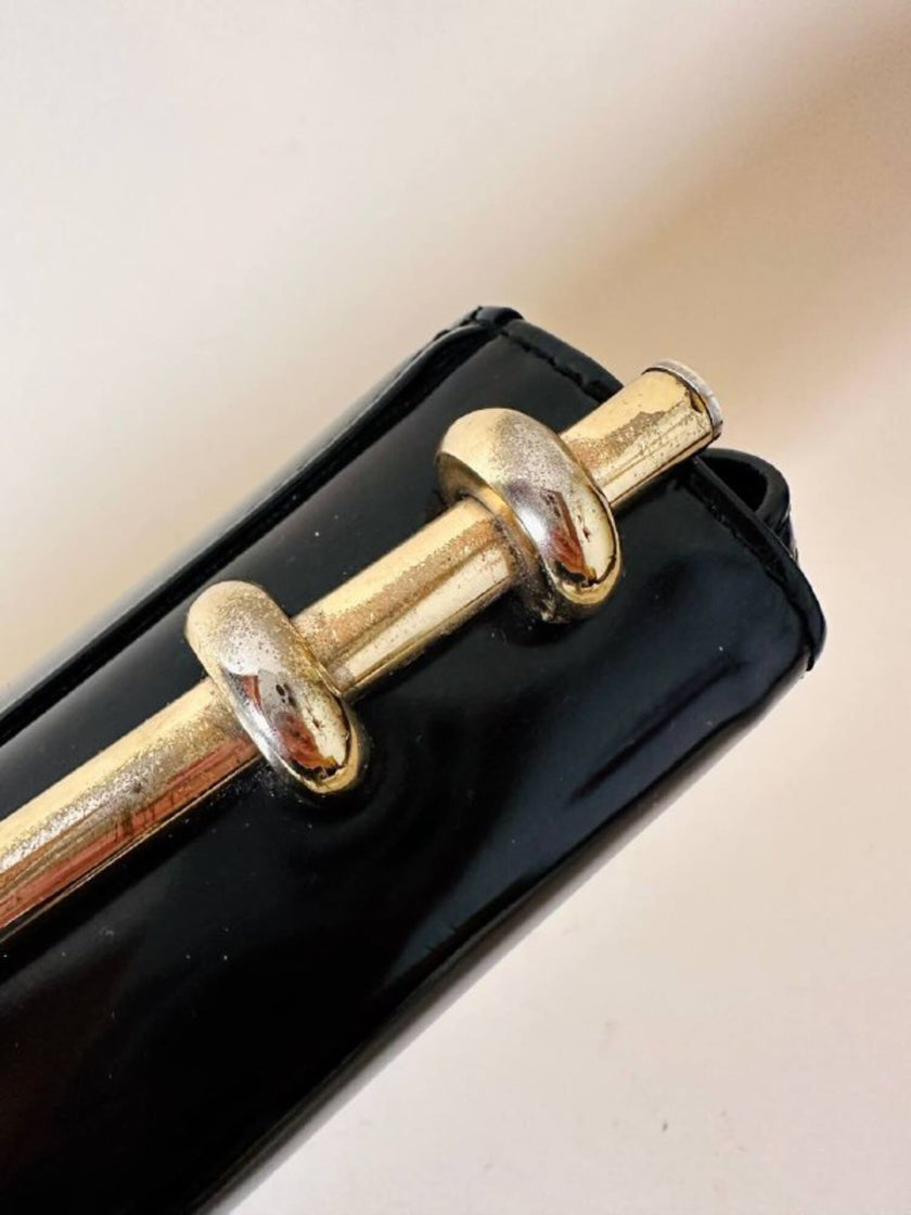 Borsa in vernice nera con manico design in metallo oro