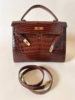 Borsa a trapezio in pelle di coccodrillo color cognac con tracolla e hardware oro Idra