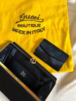 Mini pochette in tessuto nero con chiusura logata color oro “Gucci”