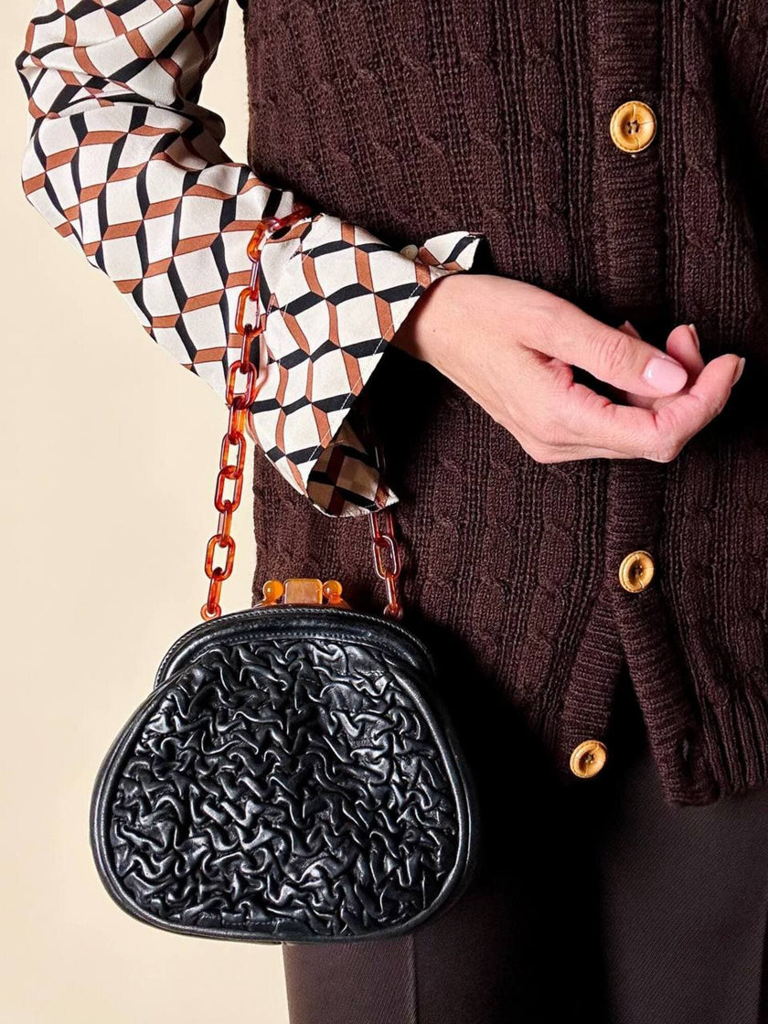 Borsa vintage in pelle nera goffrata con chiusura a scatto e catena in resina ambrata