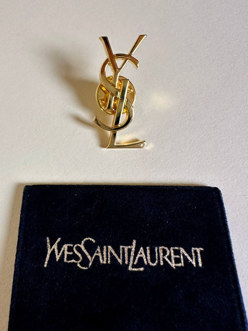 Spilla logo YSL dorata con dust nera “Yves Saint Laurent”