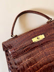 Borsa a trapezio in pelle di coccodrillo color cognac con tracolla e hardware oro Idra