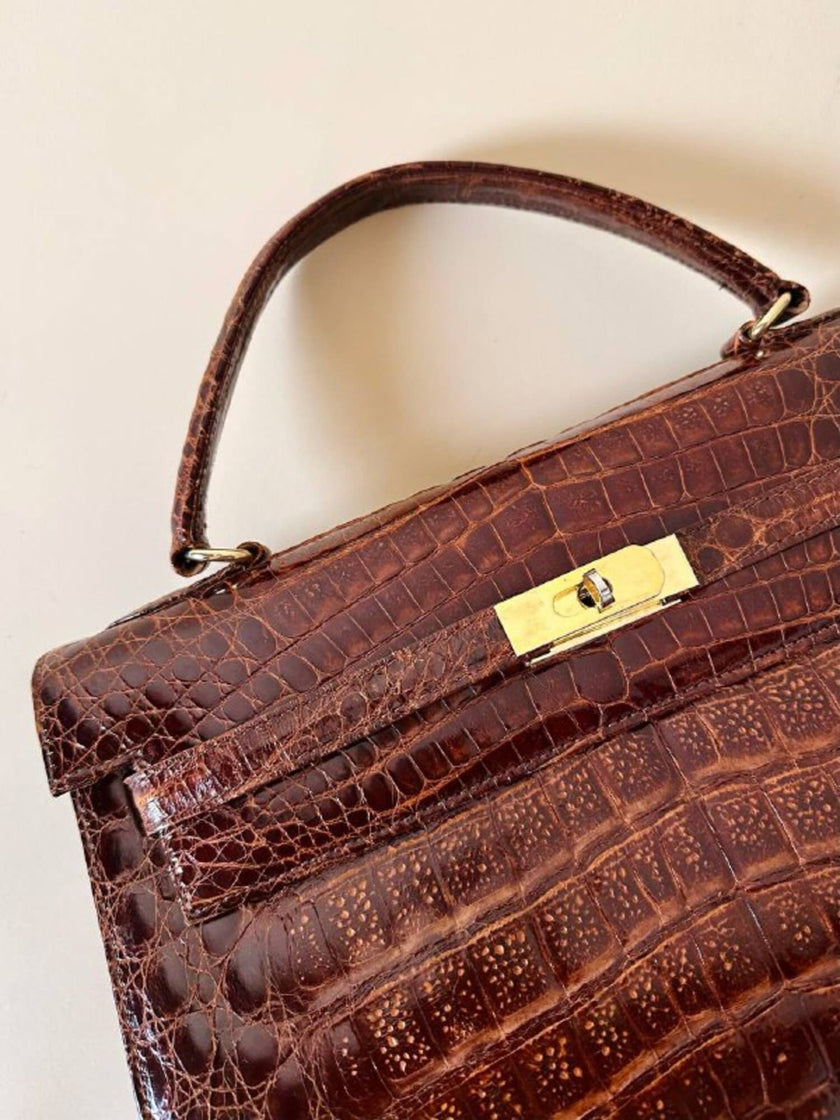 Borsa a trapezio in pelle di coccodrillo color cognac con tracolla e hardware oro Idra