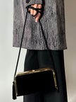 Borsa vintage in velluto nero con struttura dorata e nappe laterali