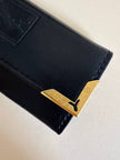 Porte-clés trifold Yves Saint Laurent en cuir noir avec détails dorés et logo YSL embossé
