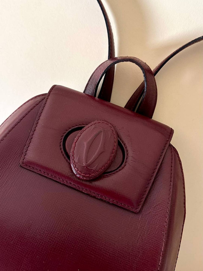 Sac à dos Must de Cartier en cuir bordeaux avec finitions dorées