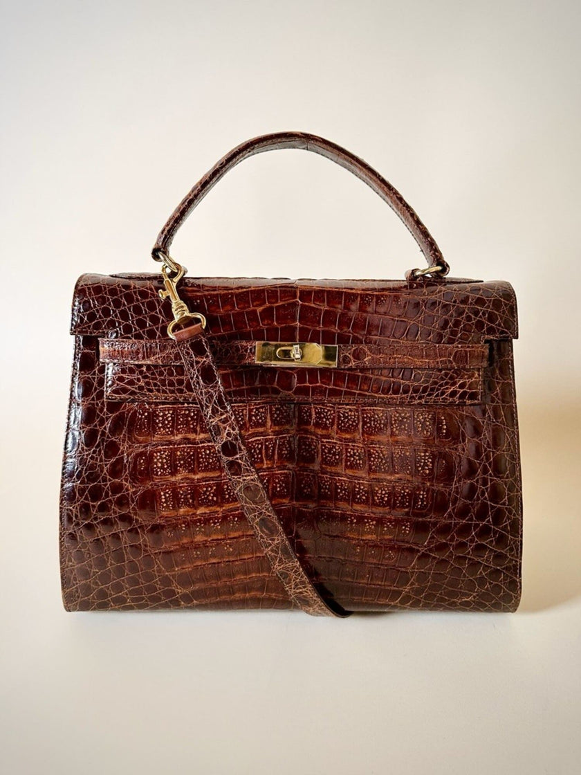 Borsa a trapezio in pelle di coccodrillo color cognac con tracolla e hardware oro Idra