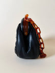 Borsa vintage in pelle nera goffrata con chiusura a scatto e catena in resina ambrata